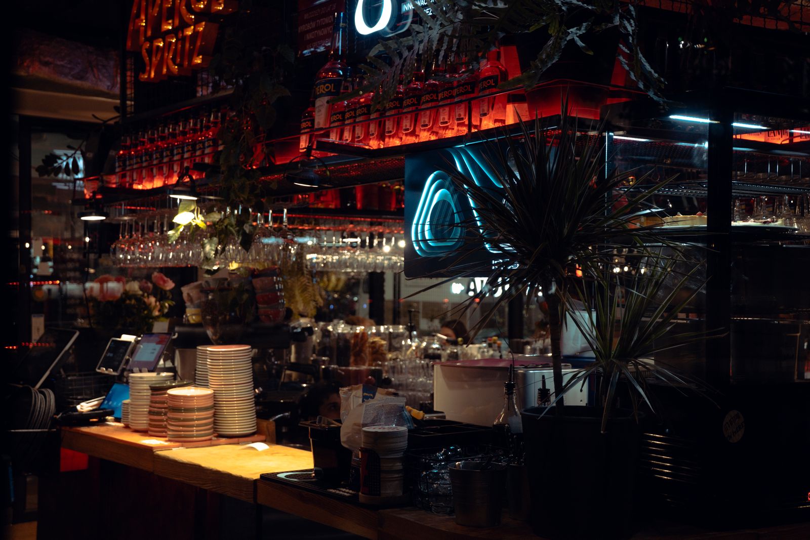 Warm lit bar scene in Katowice, showcasing Aperol decor and cozy atmosphere at night.