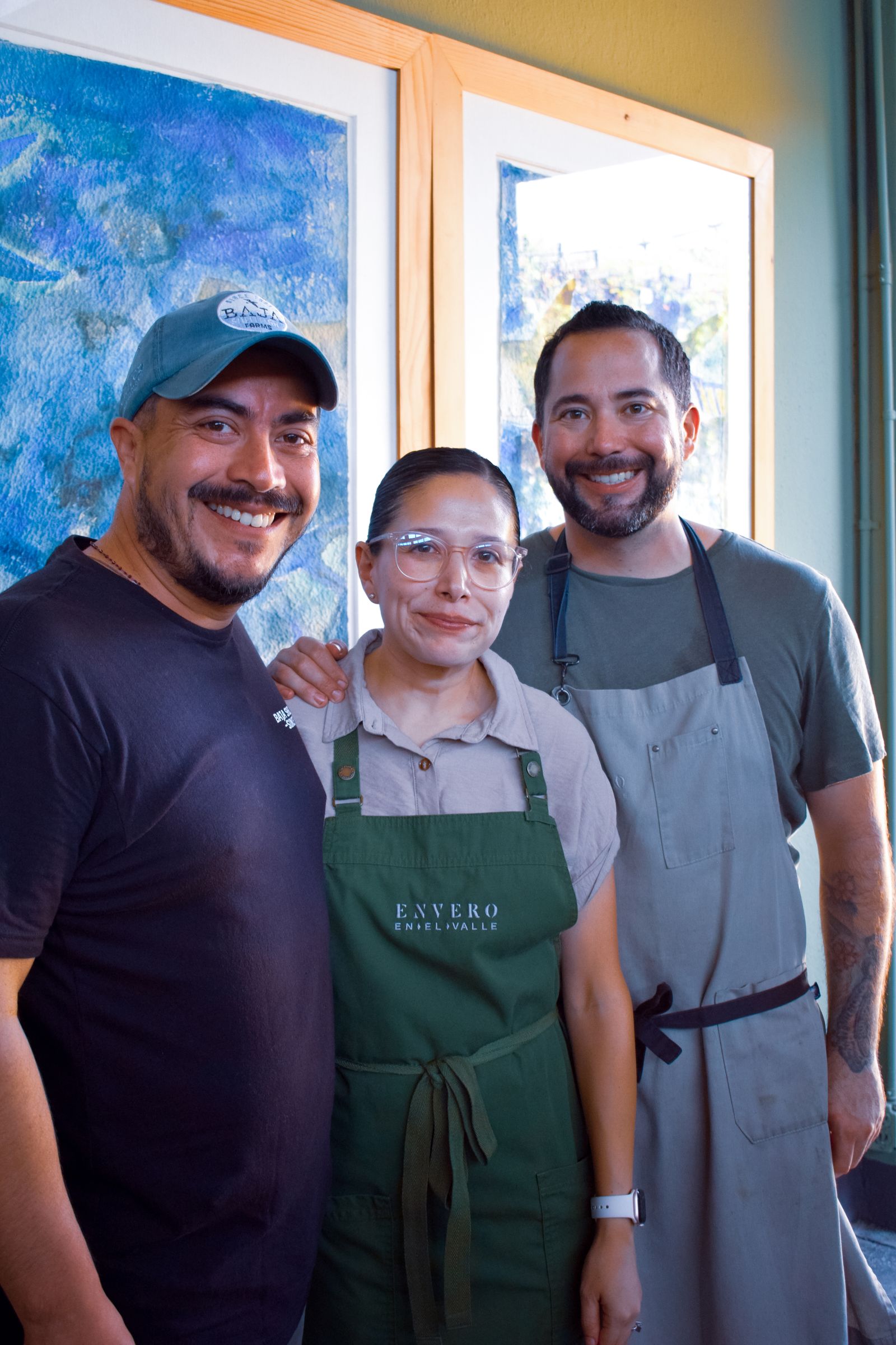 Happy restaurant staff posing inside a cafe in Ensenada, showcasing a warm and inviting atmosphere.