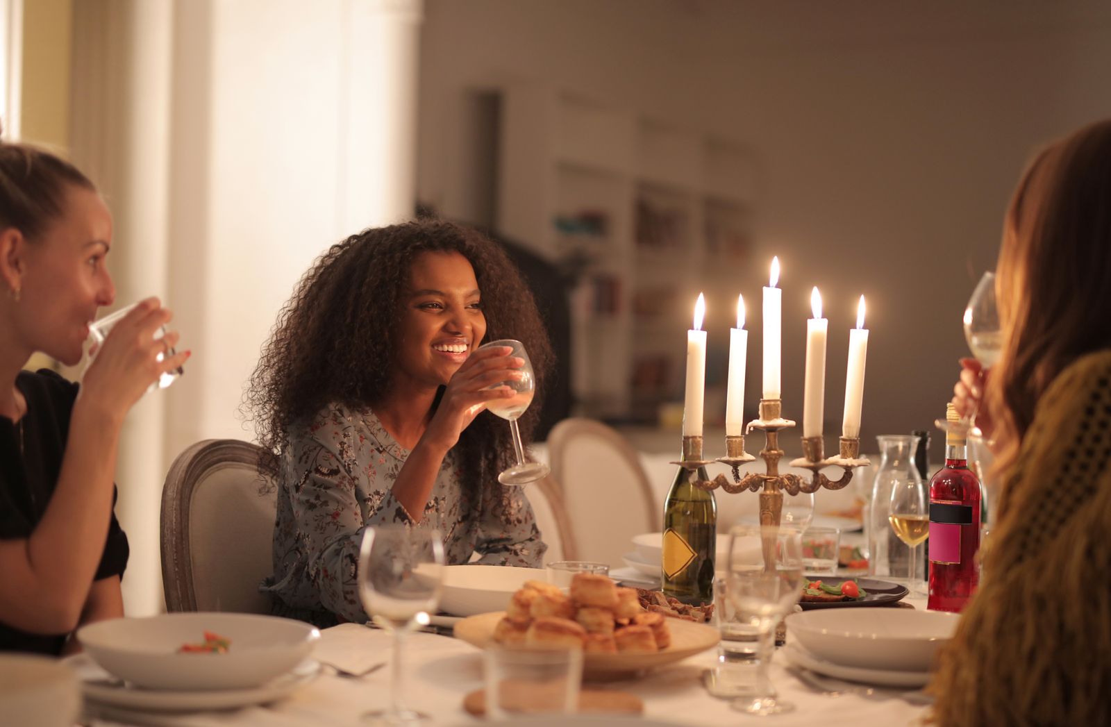 A joyful group of friends enjoying a wine dinner by candlelight, celebrating togetherness.